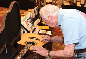 President Jimmy Carter signing a guitar in 2014.