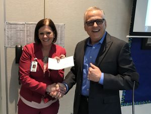 Mary Grace, Assistant Superintendent, Educational Services for Anaheim Elementary School District (AESD) receives a check for $9,000 from David Jewell, Marketing Communications Manager, Yamaha Corp. of America.