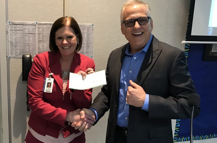 Mary Grace, Assistant Superintendent, Educational Services for Anaheim Elementary School District (AESD) receives a check for $9,000 from David Jewell, Marketing Communications Manager, Yamaha Corp. of America.